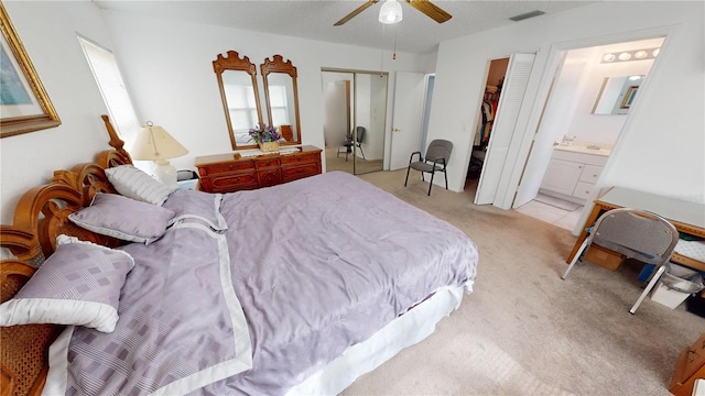 carpeted bedroom featuring connected bathroom, a textured ceiling, and ceiling fan