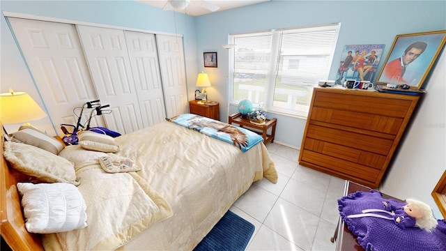 bedroom with light tile patterned flooring, ceiling fan, and a closet