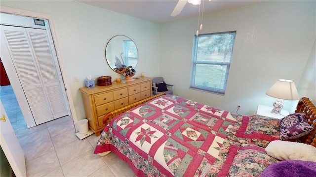 bedroom featuring light tile patterned floors, a closet, and ceiling fan