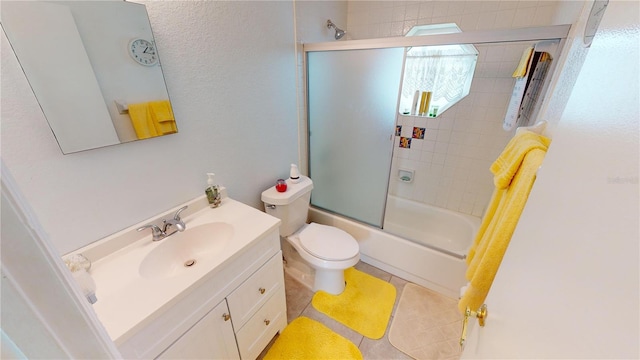 full bathroom featuring tile patterned flooring, vanity, combined bath / shower with glass door, and toilet