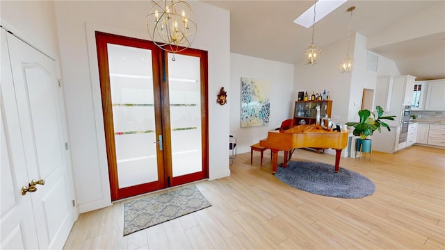 doorway featuring light hardwood / wood-style floors, a chandelier, and vaulted ceiling