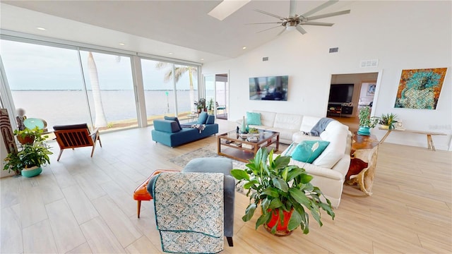 living room with ceiling fan, light hardwood / wood-style floors, and high vaulted ceiling