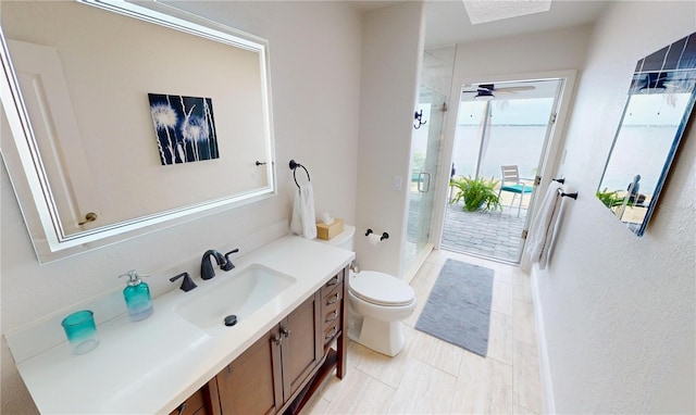 bathroom with walk in shower, vanity, ceiling fan, and toilet