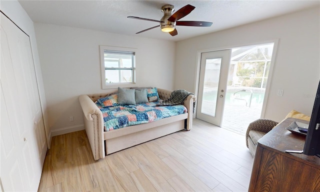 bedroom with ceiling fan, access to exterior, light hardwood / wood-style flooring, and french doors