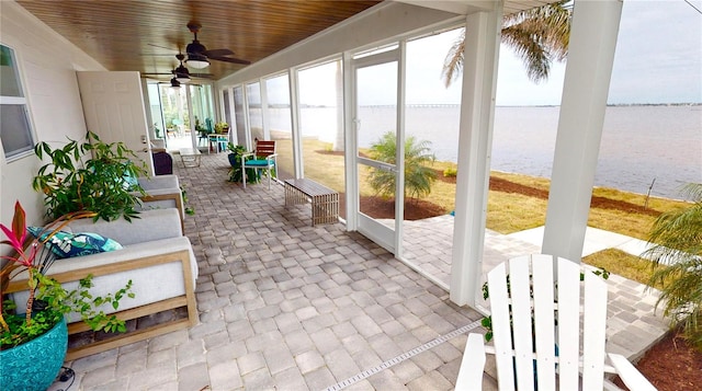 sunroom / solarium featuring ceiling fan, wooden ceiling, and a water view