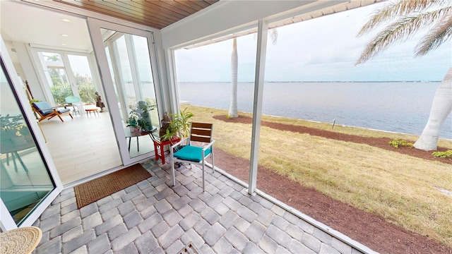 sunroom / solarium with wooden ceiling and a water view