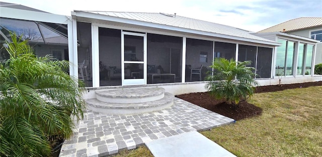 rear view of property with a sunroom and a lawn