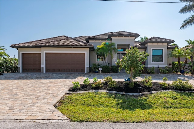 mediterranean / spanish house featuring a front yard and a garage