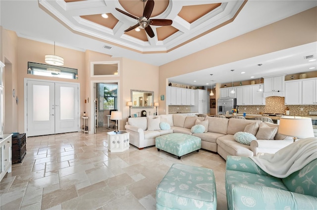 living room with beamed ceiling, ornamental molding, ceiling fan, coffered ceiling, and a high ceiling