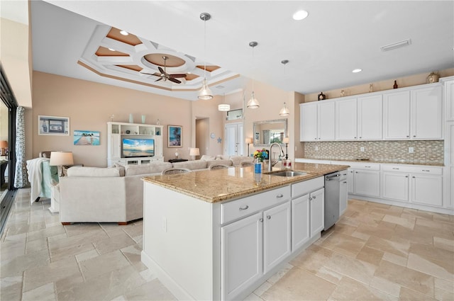 kitchen with ceiling fan, an island with sink, decorative light fixtures, and white cabinetry