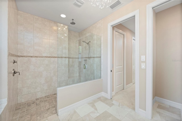 bathroom with a notable chandelier and tiled shower