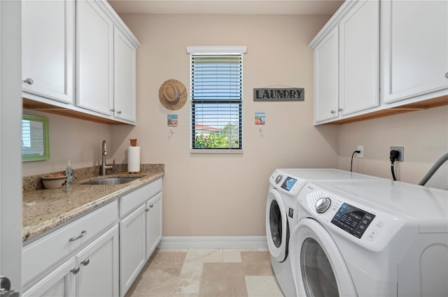 laundry area featuring washer and dryer, cabinets, and sink