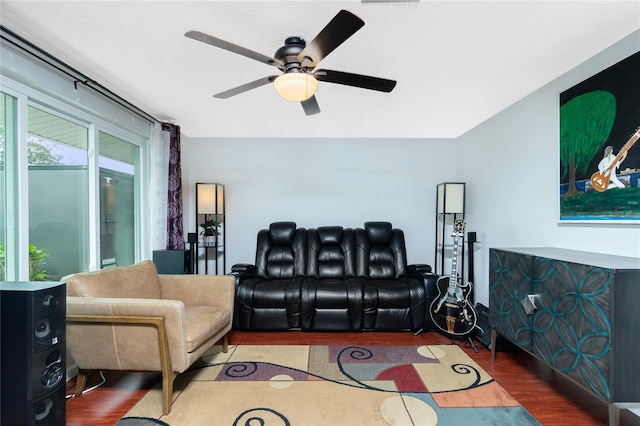 living room featuring ceiling fan and dark hardwood / wood-style floors