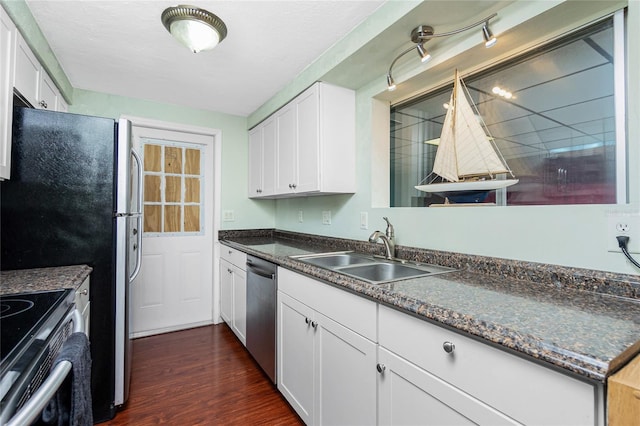 kitchen with appliances with stainless steel finishes, sink, white cabinets, and dark hardwood / wood-style floors