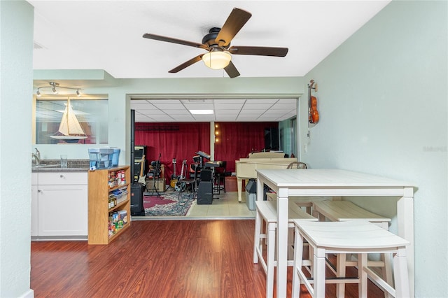 dining room featuring hardwood / wood-style flooring, a paneled ceiling, and ceiling fan