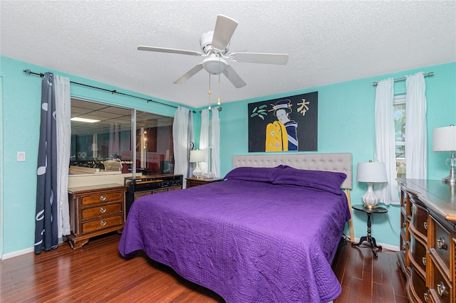 bedroom with ceiling fan, dark hardwood / wood-style floors, and a textured ceiling