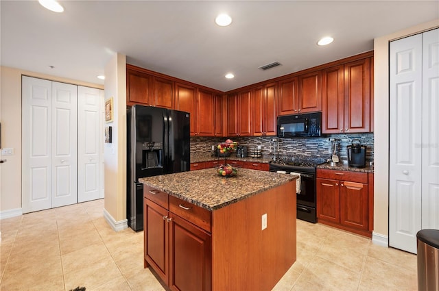 kitchen featuring a center island, light tile patterned floors, visible vents, dark stone countertops, and black appliances