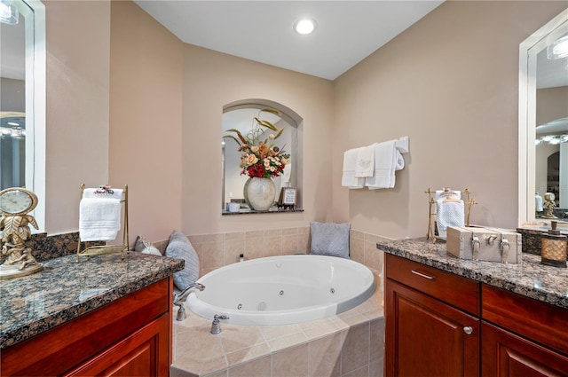 bathroom with a jetted tub, vanity, and recessed lighting