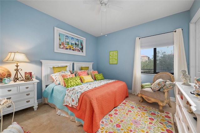 bedroom featuring light colored carpet, ceiling fan, and baseboards