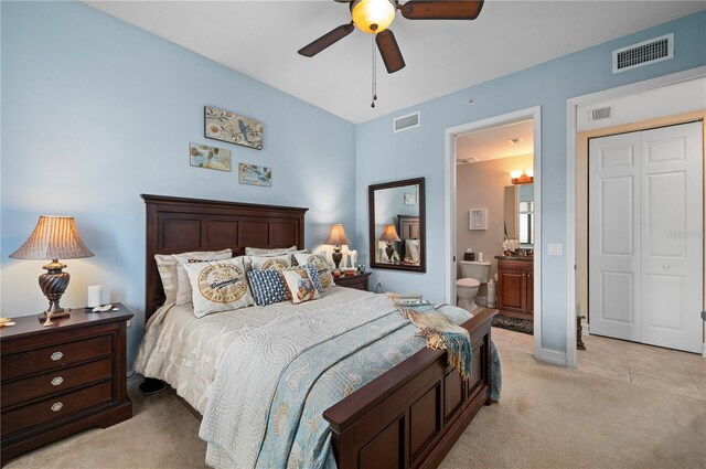 bedroom with visible vents, connected bathroom, and light colored carpet