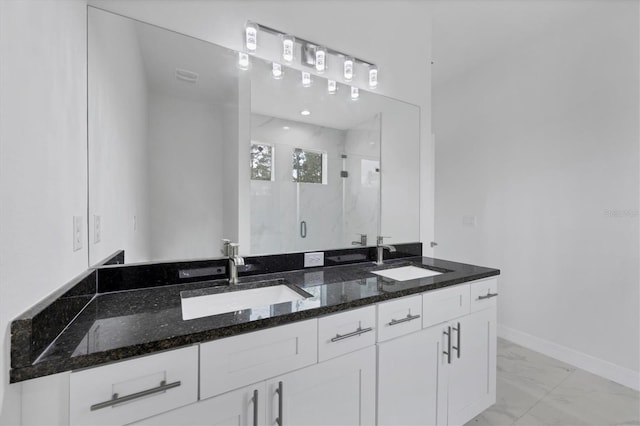 bathroom featuring a shower with door and vanity