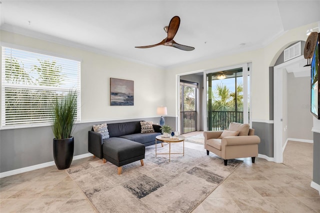 living room with ceiling fan, ornamental molding, and a wealth of natural light