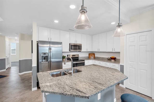 kitchen featuring a center island with sink, stainless steel appliances, hanging light fixtures, sink, and white cabinetry