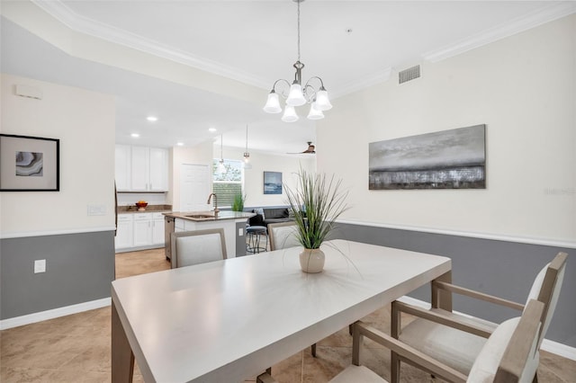 dining space featuring sink, an inviting chandelier, light tile patterned floors, and crown molding