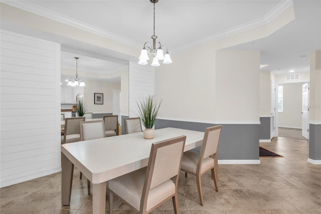 dining room with a fireplace, an inviting chandelier, light tile patterned flooring, and crown molding