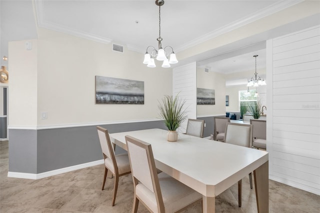 tiled dining area featuring an inviting chandelier and ornamental molding