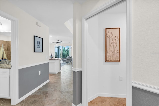 hallway with light tile patterned flooring and sink