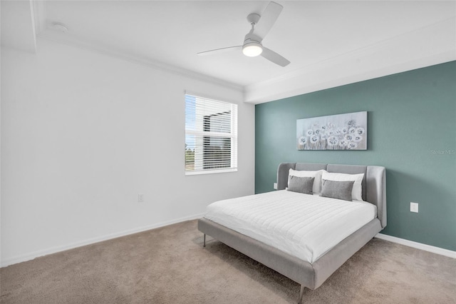 carpeted bedroom with ceiling fan and ornamental molding