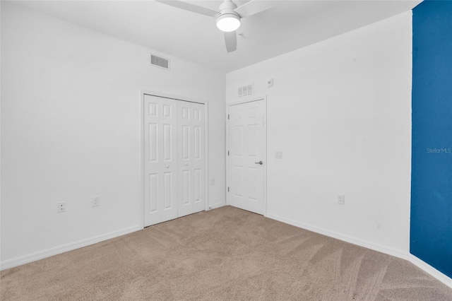 unfurnished bedroom with carpet floors, ceiling fan, and a closet