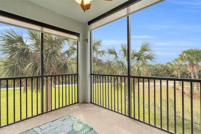 unfurnished sunroom with ceiling fan