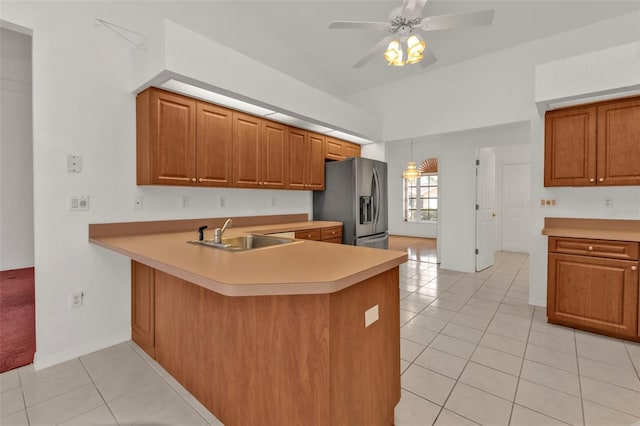 kitchen with sink, stainless steel fridge with ice dispenser, kitchen peninsula, ceiling fan, and light tile patterned floors