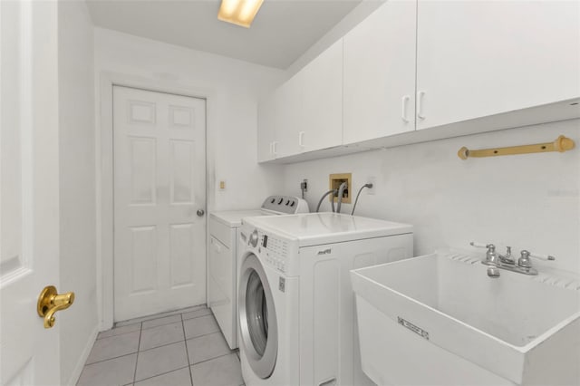 washroom featuring light tile patterned flooring, sink, cabinets, and washing machine and clothes dryer