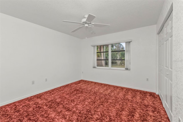 carpeted spare room with ceiling fan and a textured ceiling