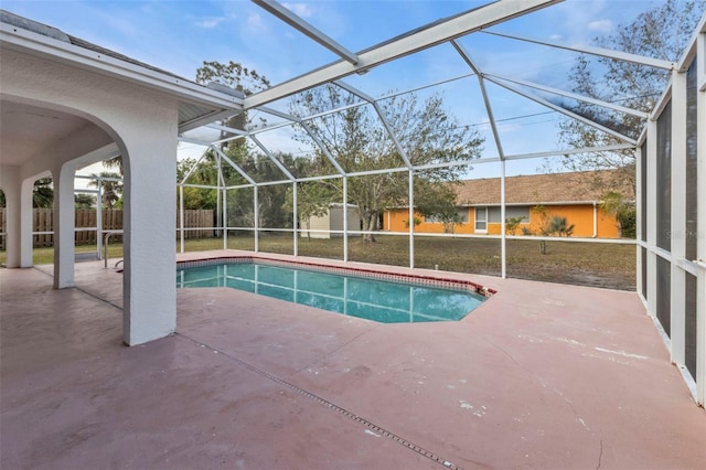 view of pool featuring a patio area, a lanai, and a storage unit