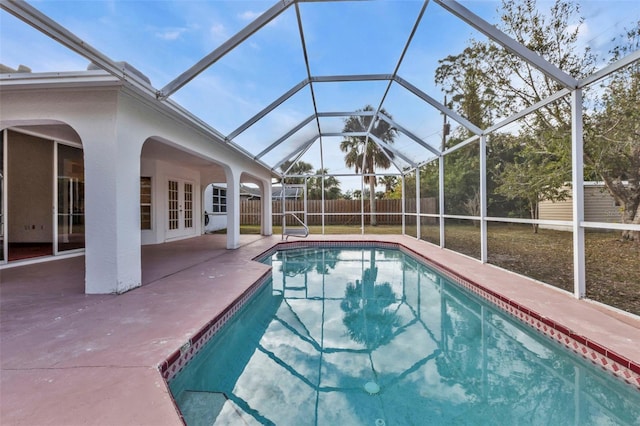 view of pool featuring glass enclosure, a patio area, and french doors