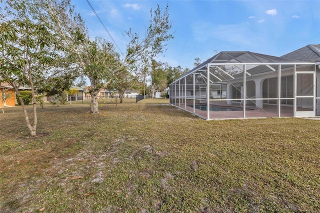 view of yard featuring glass enclosure and a patio