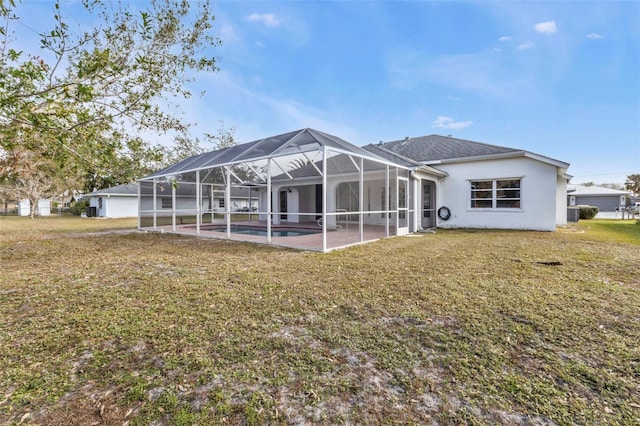 rear view of property with a lanai, a lawn, and a patio