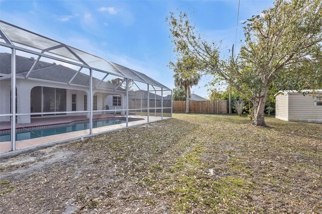 view of yard with a fenced in pool, a storage shed, and glass enclosure