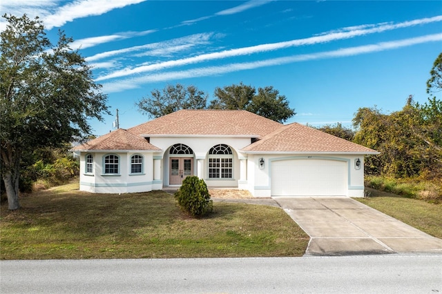 mediterranean / spanish-style house with a garage and a front lawn