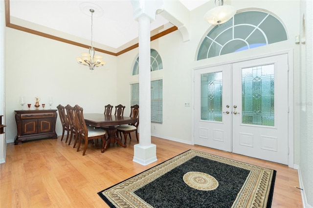 entryway with light hardwood / wood-style floors, an inviting chandelier, and french doors