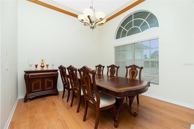 dining space featuring crown molding, a chandelier, and light wood-type flooring