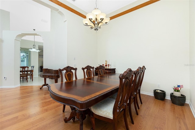 dining space featuring an inviting chandelier, crown molding, and light hardwood / wood-style flooring