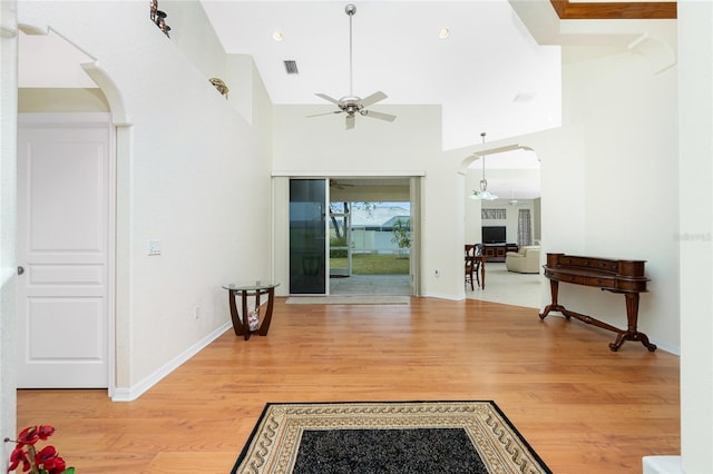 interior space featuring hardwood / wood-style floors, ceiling fan, and a high ceiling