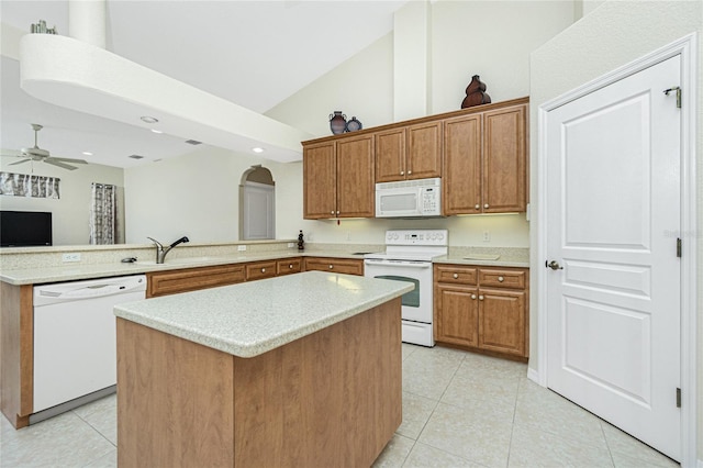 kitchen with light tile patterned flooring, sink, a center island, kitchen peninsula, and white appliances