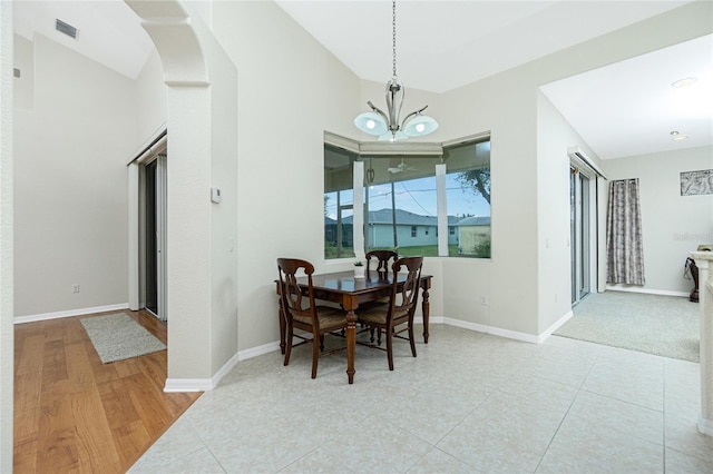 dining space with light tile patterned flooring and an inviting chandelier