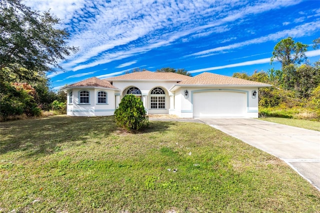 mediterranean / spanish-style house featuring a garage and a front lawn